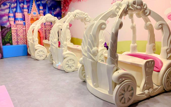 Indoor play area with carriage-themed seating at Amazonia Singapore.