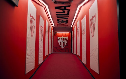 Players' tunnel at Ramón Sánchez-Pizjuán Stadium with Sevilla FC logos on red walls.