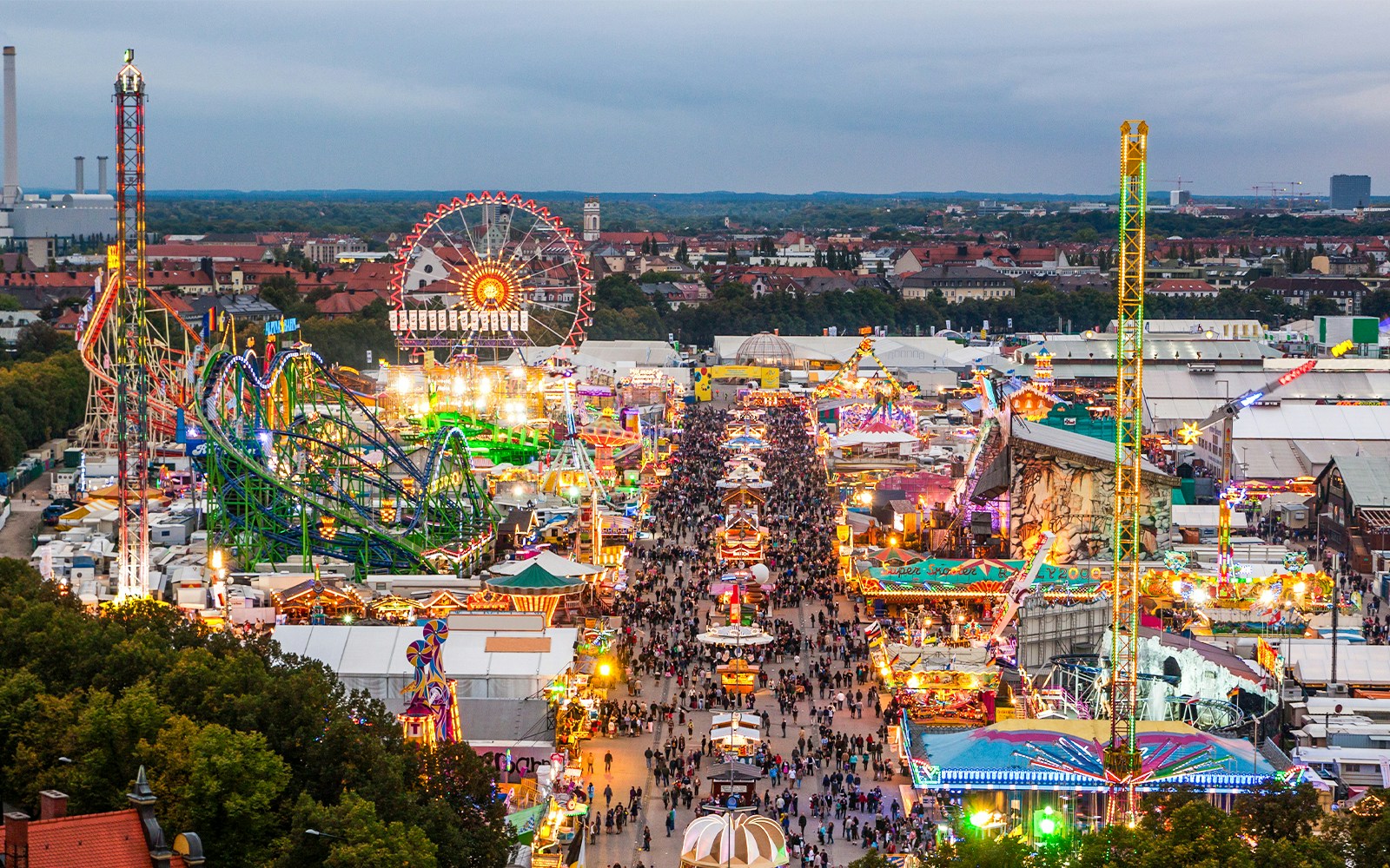 Oktoberfest tents and Ferris wheel illuminated at night in Munich, Germany.