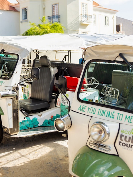 Eco tuk tuks parked in Lisbon street, ready for tours.
