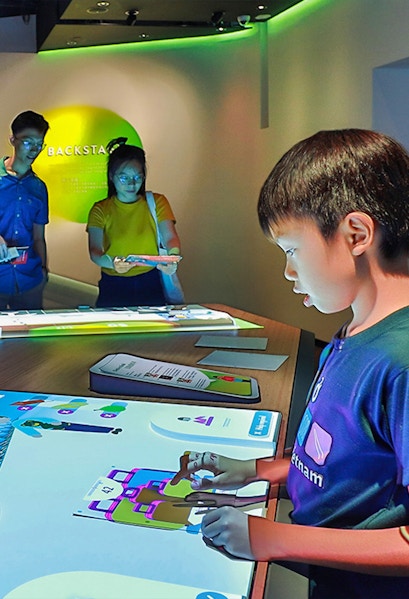 Child interacting with digital exhibit at Petrosains Discovery Centre.