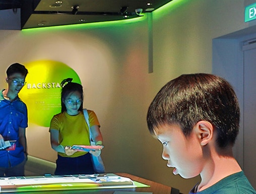 Child interacting with digital exhibit at Petrosains Discovery Centre.