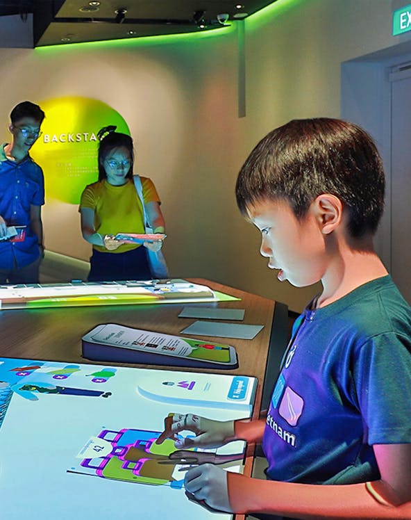 Child interacting with digital exhibit at Petrosains Discovery Centre.