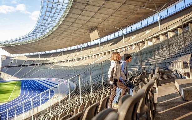 Guests exploring Olympiastadion Berlin, walking through historic stadium grounds.