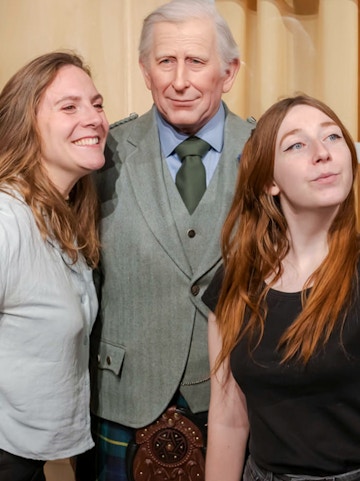 Visitors posing with a wax figure at the Grévin Museum in Paris.