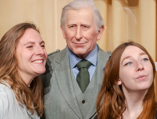 Visitors posing with a wax figure at the Grévin Museum in Paris.