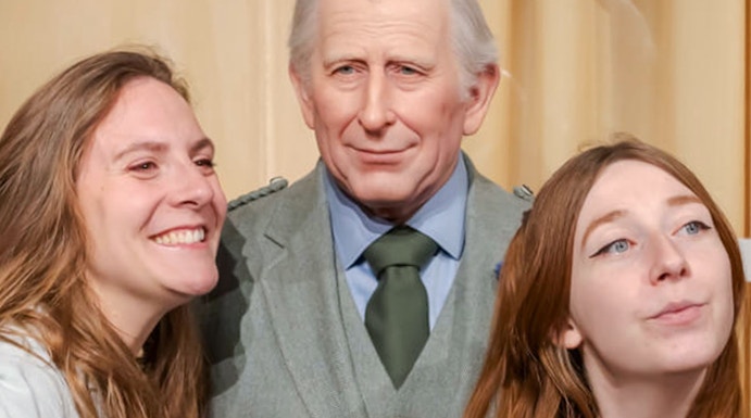 Visitors posing with a wax figure at the Grévin Museum in Paris.