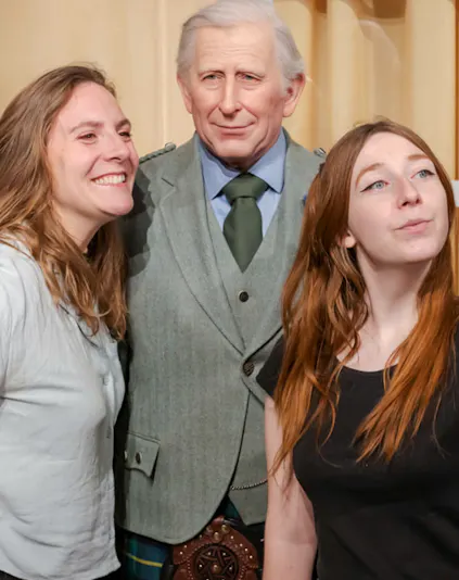 Visitors posing with a wax figure at the Grévin Museum in Paris.
