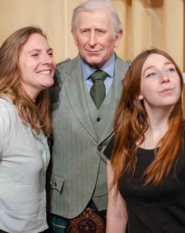 Visitors posing with a wax figure at the Grévin Museum in Paris.