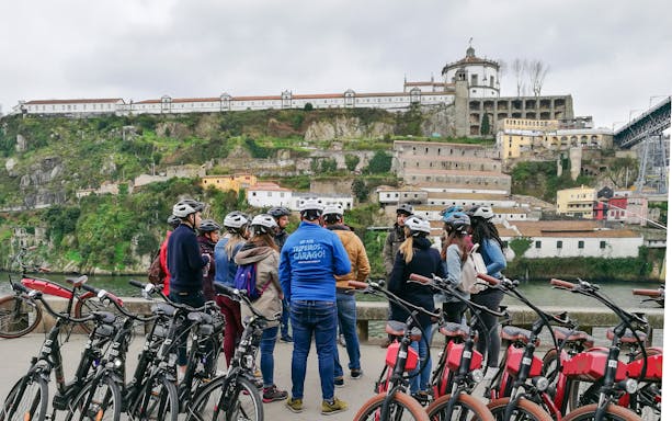 Group of cyclists on a guided tour near Porto's Old Town and riverside.