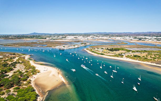 Aerial view of boats near sandy beaches on a 4 Islands Guided Tour in Faro, Portugal.