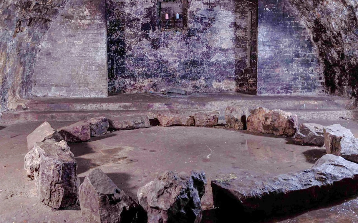 Stone circle in a dimly lit underground vault, part of the Terror Tour in Edinburgh.