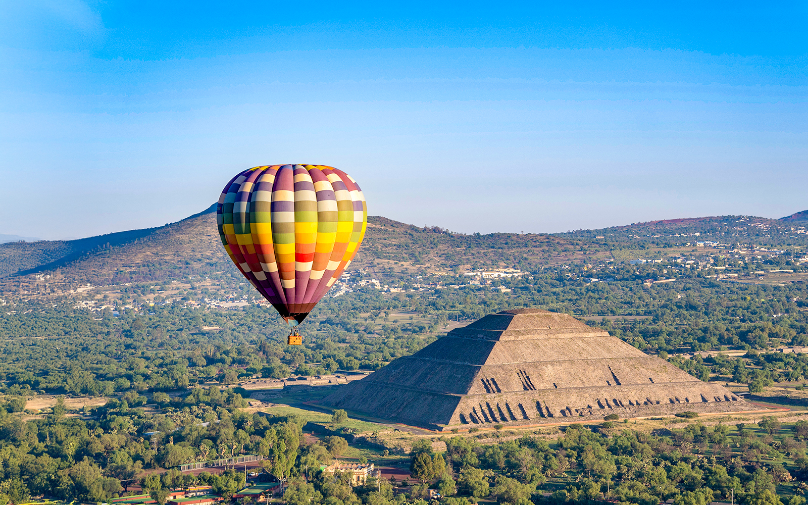 Hot air balloon floating over Teotihuacan pyramids, Mexico.