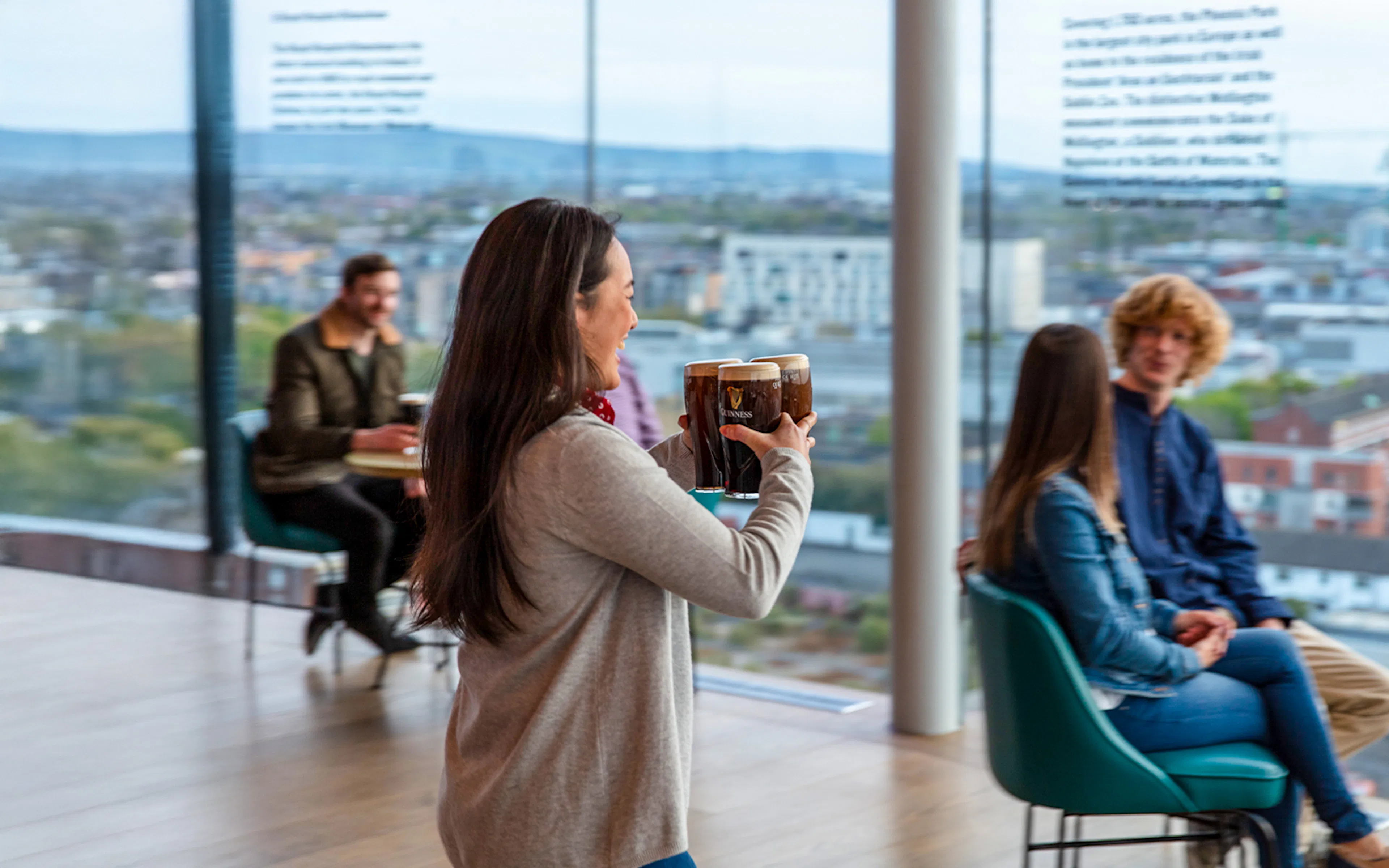 Guests enjoying drinks at the Guinness Storehouse Gravity Bar, Dublin, with panoramic city views.