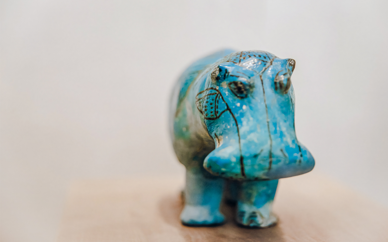 Bright blue faience hippopotamus figurine with black details at Metropolitan Museum of Art.