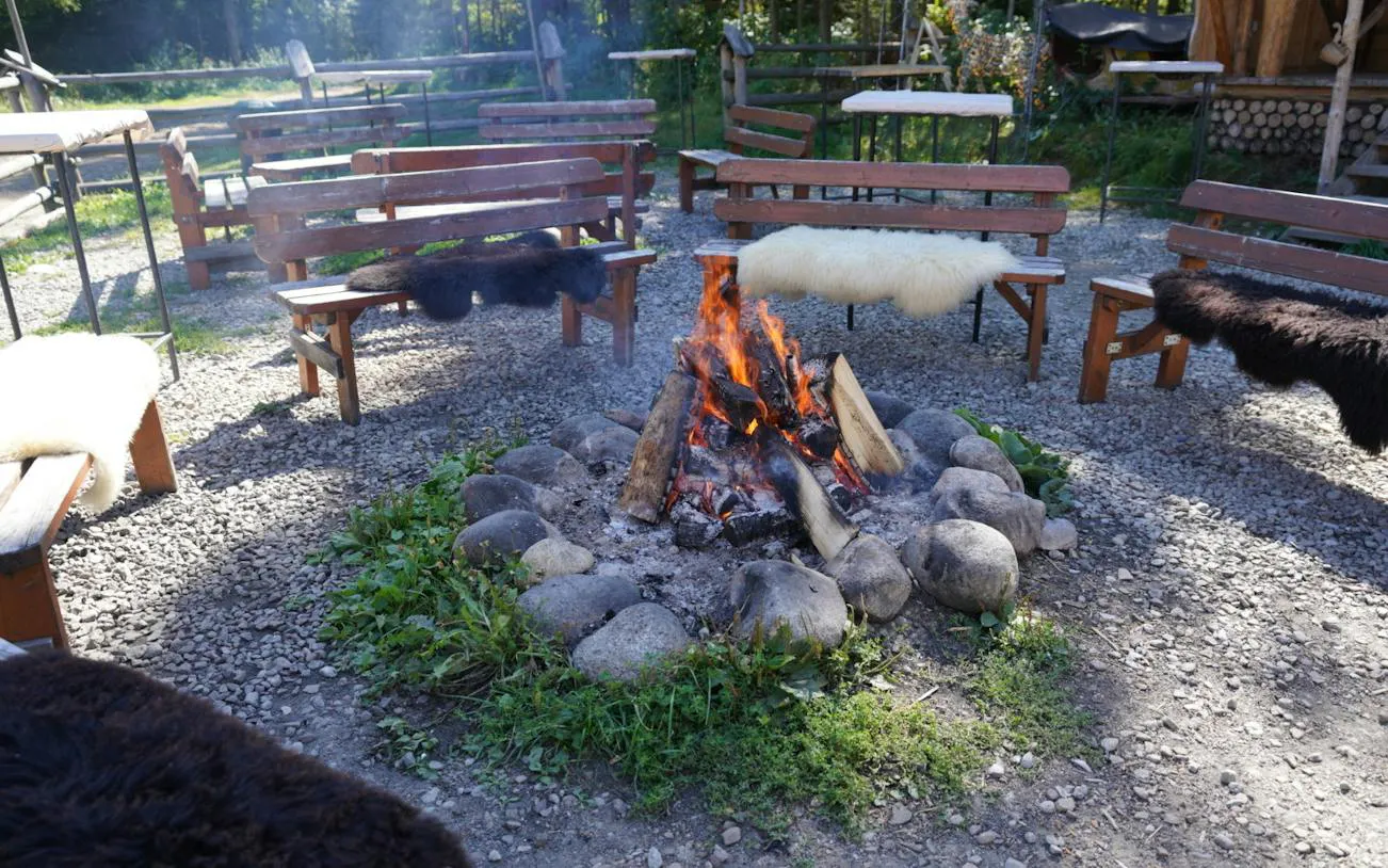 Outdoor seating around a campfire in Poronin, part of the Krakow SkyWalk and sleigh ride tour.