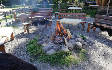 Outdoor seating around a campfire in Poronin, part of the Krakow SkyWalk and sleigh ride tour.