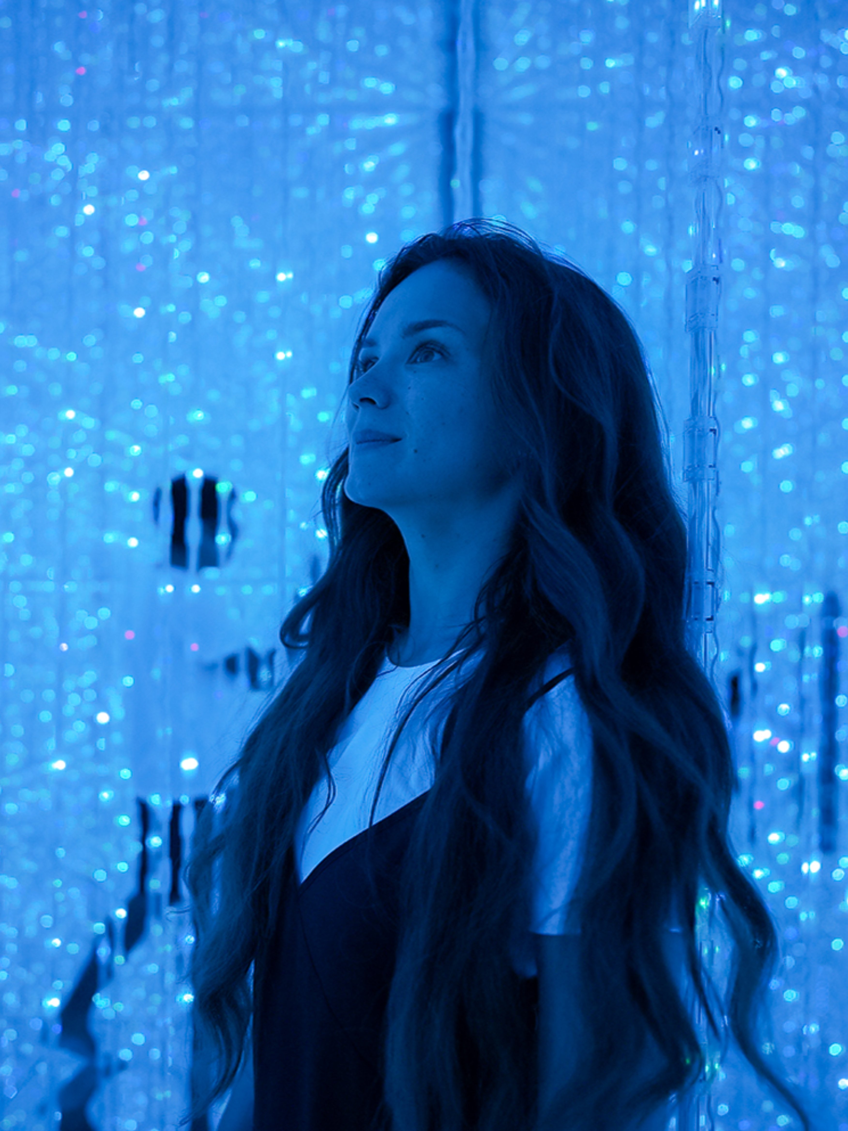 Woman in futuristic setting with glowing blue digital lights.