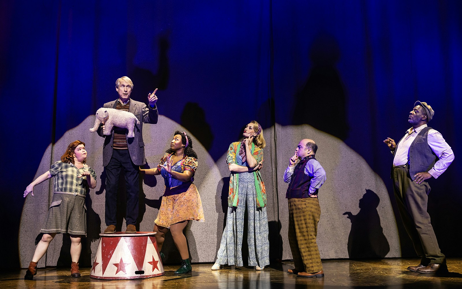 Performers on stage with a small elephant prop during a "Water for Elephants" scene.