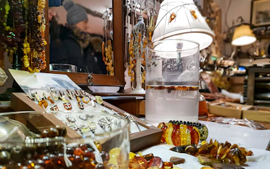 Amber jewelry display at Gdańsk workshop with necklaces and rings.