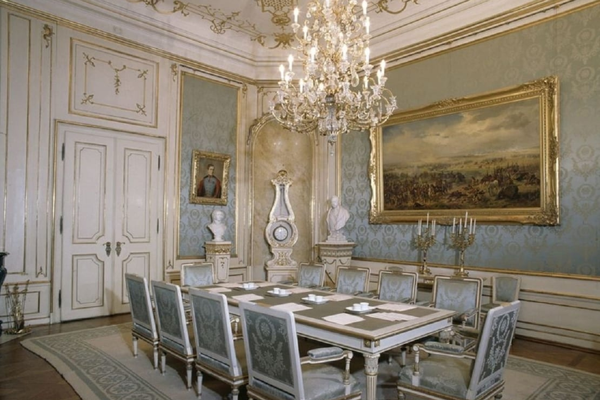 Dining room in the Imperial Apartments, Hofburg Palace, Vienna, featuring ornate decor and chandeliers.