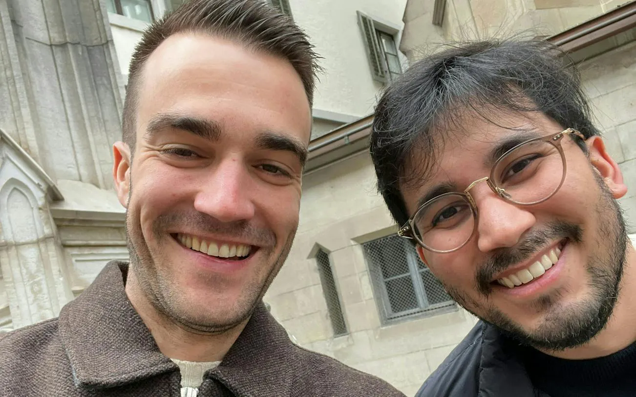 Two people smiling in front of a historic building in Zurich during a self-guided city exploration game.
