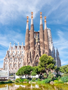Sagrada Familia towers in Barcelona with intricate facade and surrounding greenery.