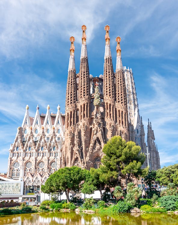 Sagrada Familia towers in Barcelona with intricate facade and surrounding greenery.