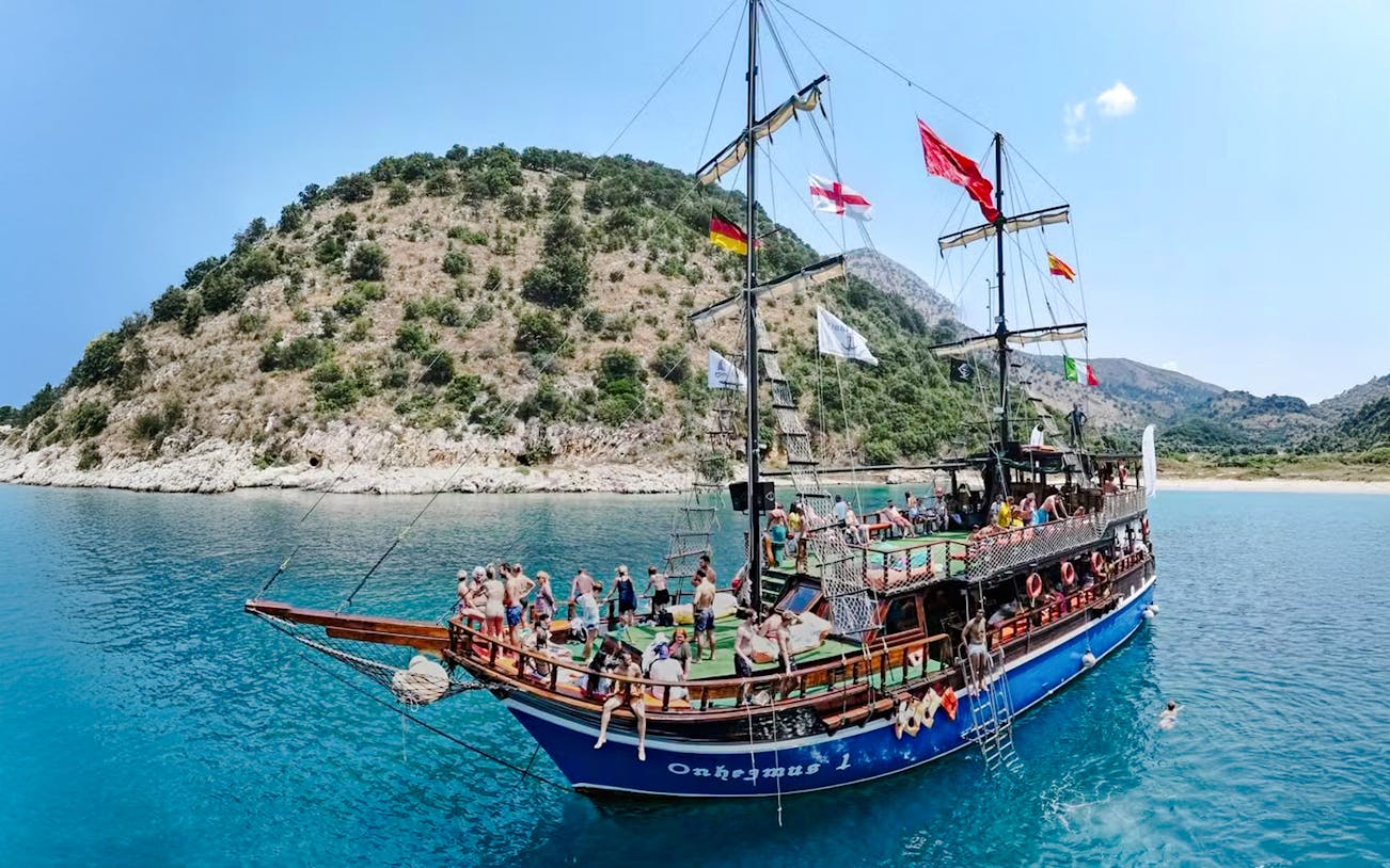 Pirate ship tour with passengers near Saranda coastline.
