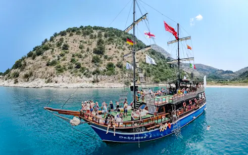 Pirate ship tour with passengers near Saranda coastline.