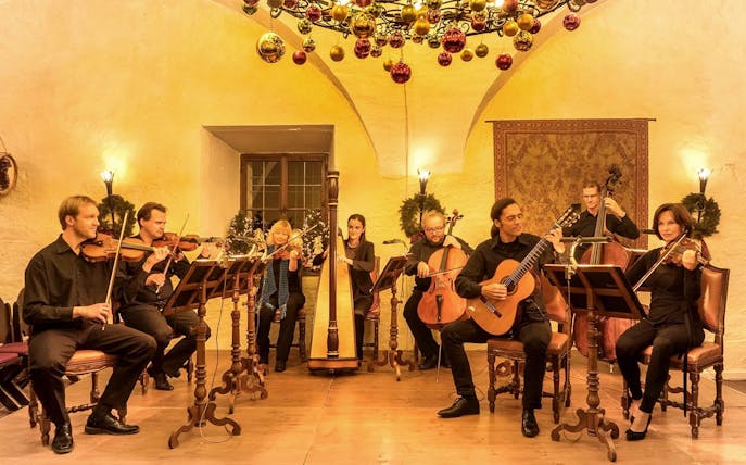 Musicians performing at Fortress Hohensalzburg Christmas Advent concert with festive decor.