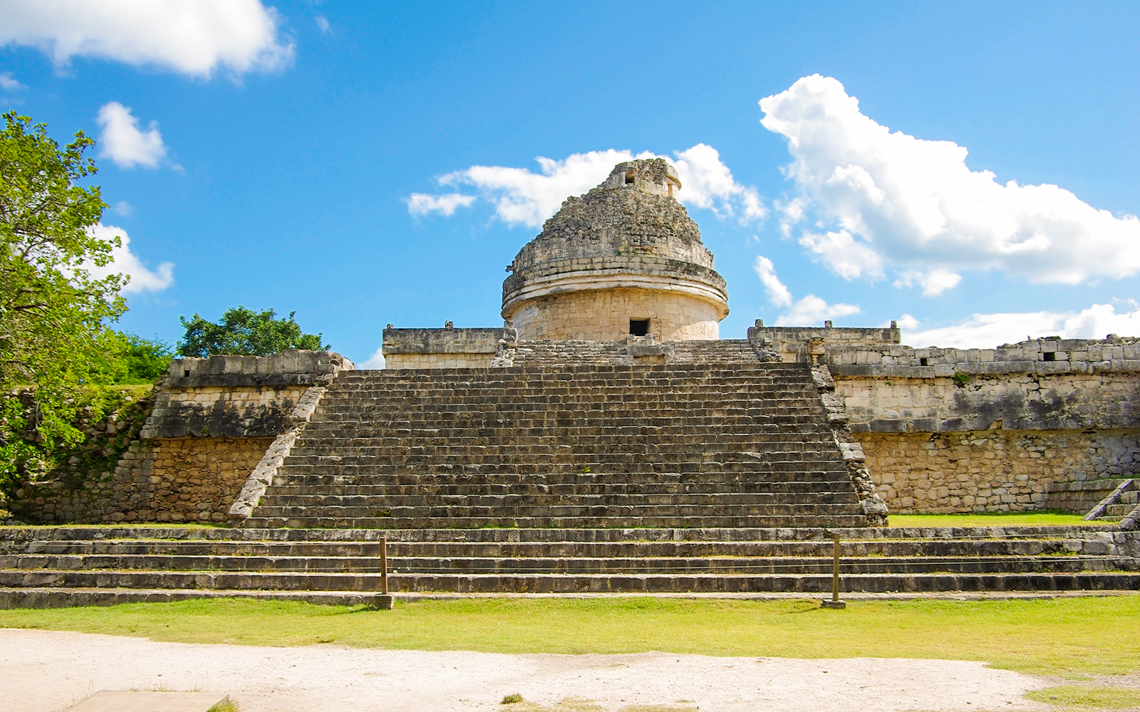 Chichen Itza observatory with stone steps under a blue sky.