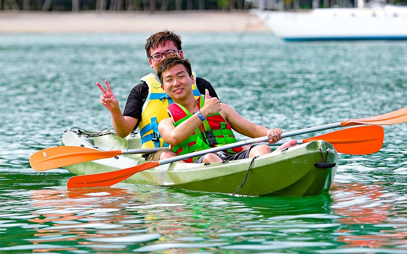 Kayaking at Paradise 101 with two people in life jackets on a green kayak.