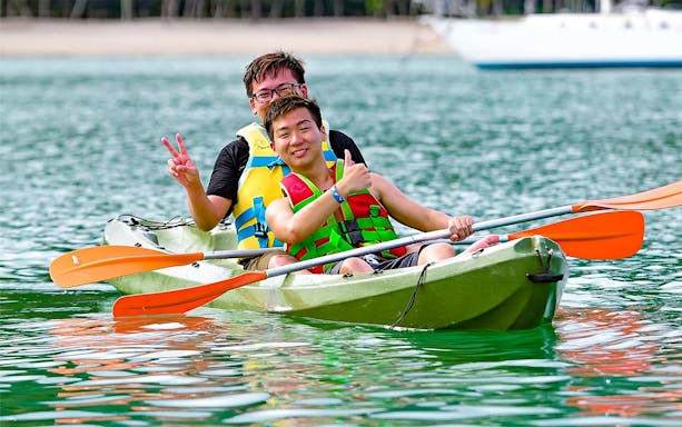 Kayaking at Paradise 101 with two people in life jackets on a green kayak.