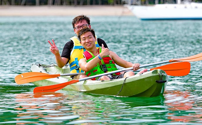 Kayaking at Paradise 101 with two people in life jackets on a green kayak.