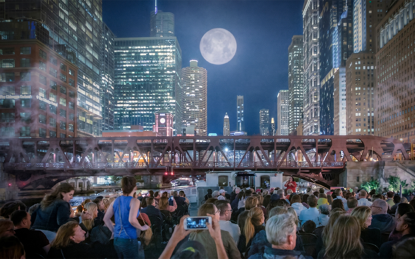 Crowd on Chicago Haunted River "Creepy Cruise" by First Lady under moonlit skyline.