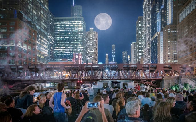 Crowd on Chicago Haunted River "Creepy Cruise" by First Lady under moonlit skyline.