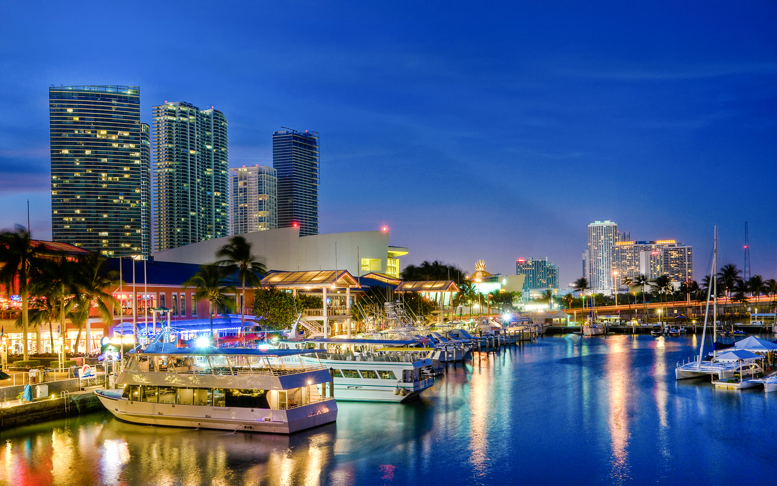Bayside Marketplace waterfront with boats and Miami skyline at dusk.