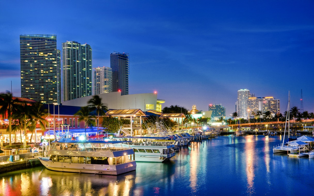 Bayside Marketplace waterfront with boats and Miami skyline at dusk.