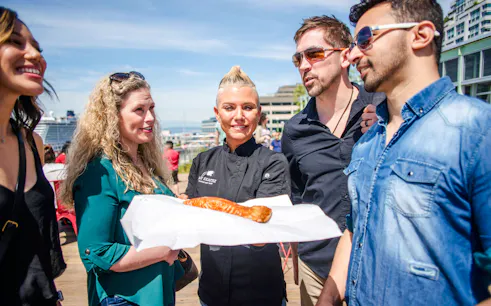 Chef presenting smoked salmon to group at Pike Place Market food tour.