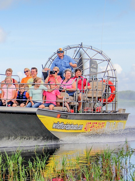 Guests on an airboat tour in the Everglades, gliding through wetlands.