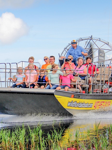 Guests on an airboat tour in the Everglades, gliding through wetlands.