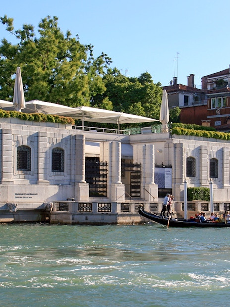 Peggy Guggenheim Collection museum along Venice's Grand Canal with gondola passing by.