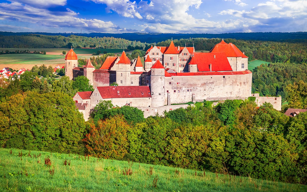 Harburg Castle with red roofs surrounded by lush greenery on the Romantic Road, Germany.