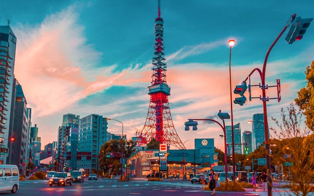 Tokyo Tower at sunset with city traffic below.