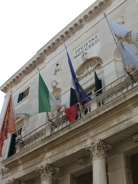 Facade of a historic building with flags in Venice, Italy.