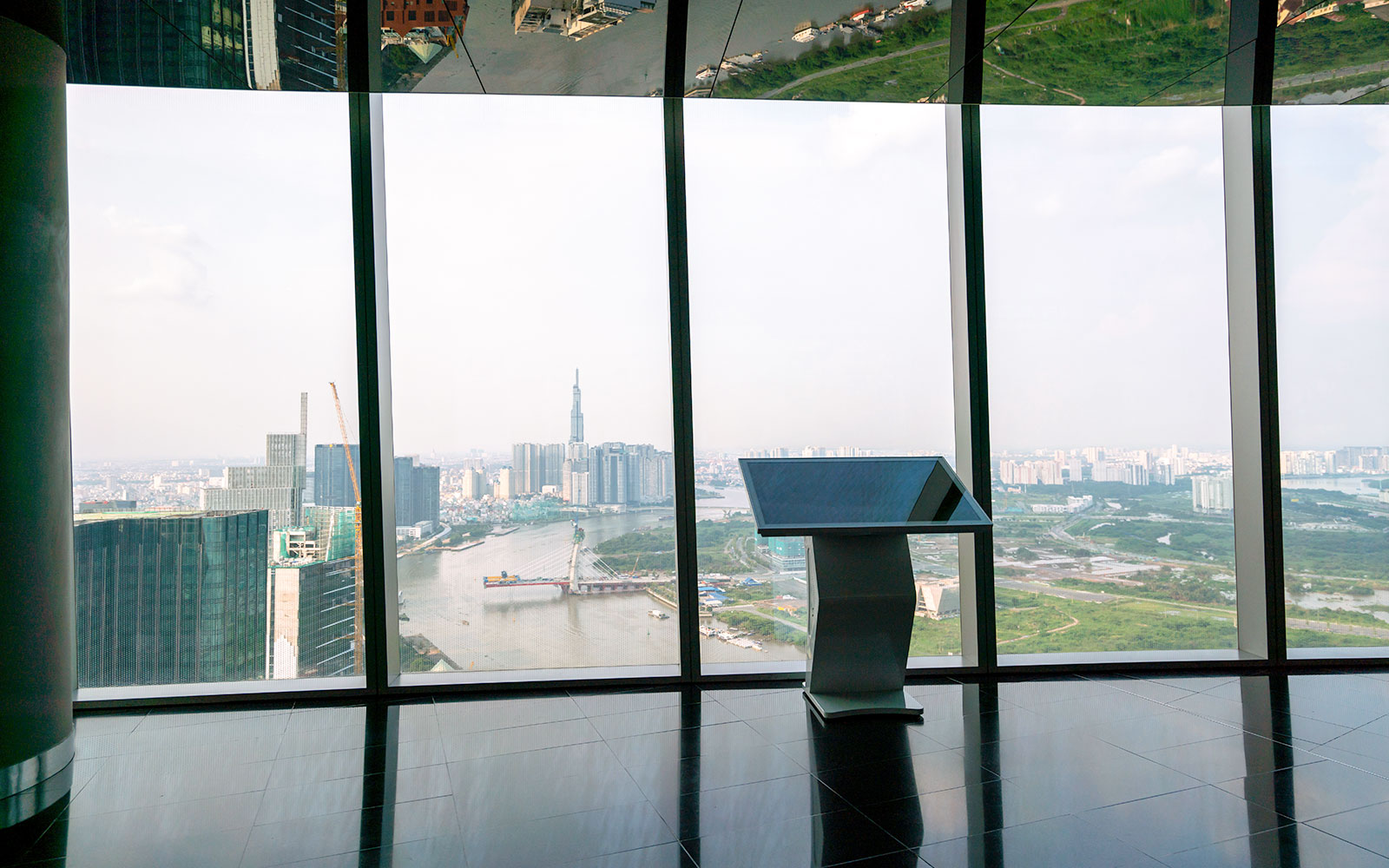 Sky deck view of downtown Ho Chi Minh City, Vietnam with river and skyscrapers.