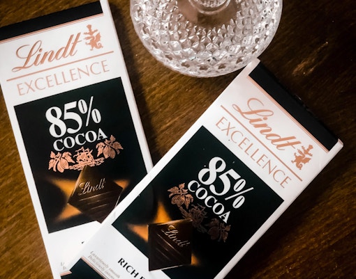 Lindt dark chocolate bars on a wooden table, related to Jungfraujoch tour.
