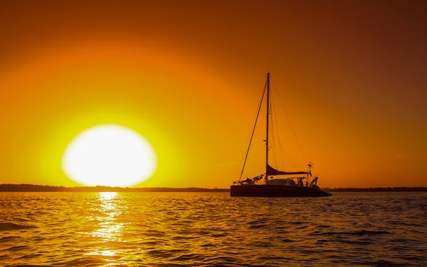 Catamaran sailing at sunset off the coast of Valencia.