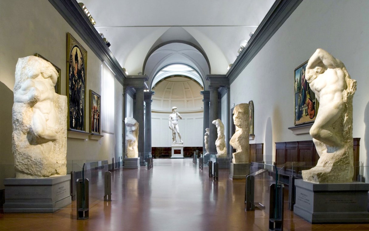 Visitors at Florence's Accademia Gallery viewing Michelangelo's David statue.